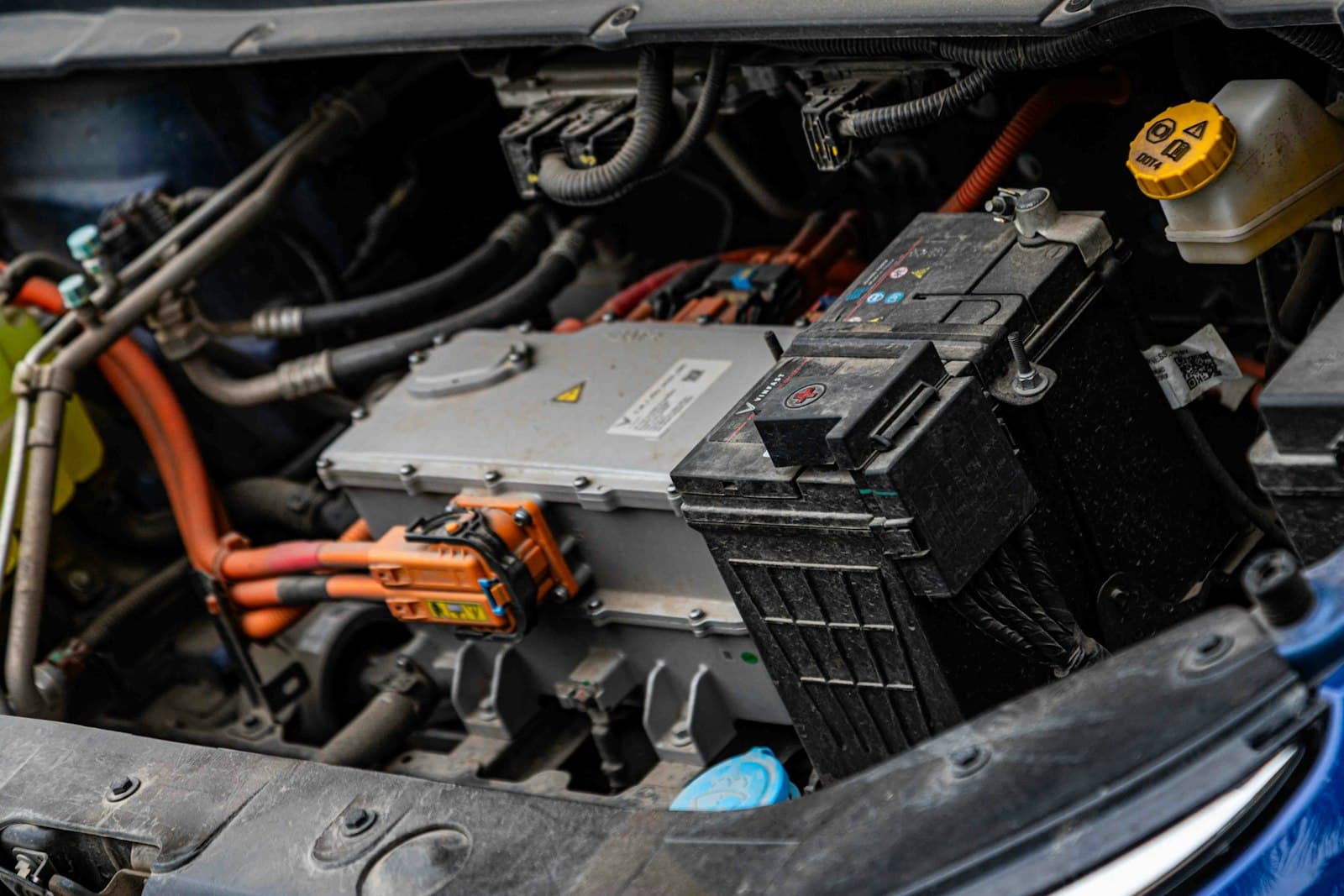 Le compartiment d’une voiture électrique, avec sa batterie haute tension et ses câbles orange