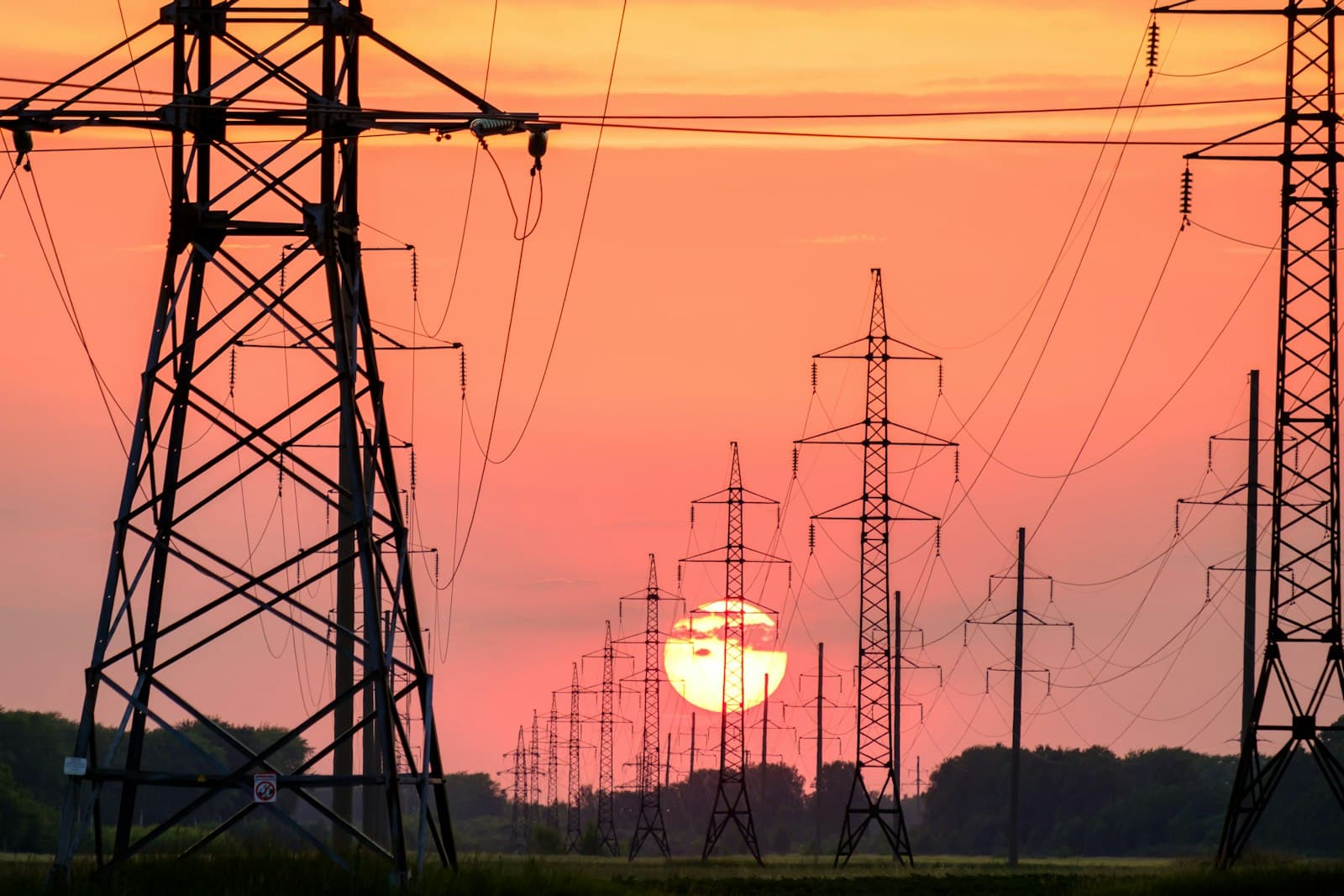 Des pylônes électriques au coucher du soleil