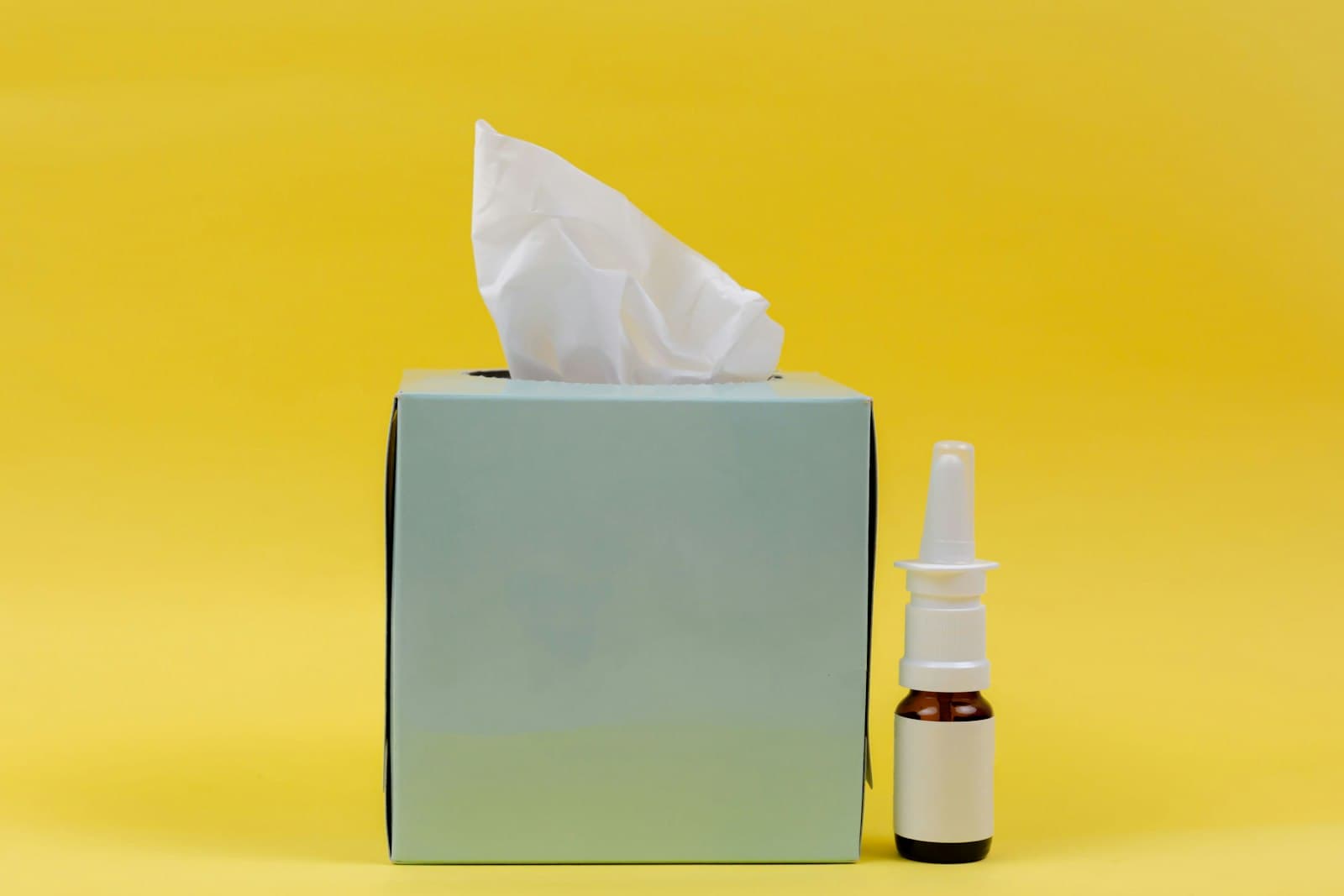 Un flacon de médicament près d’une boîte de mouchoirs