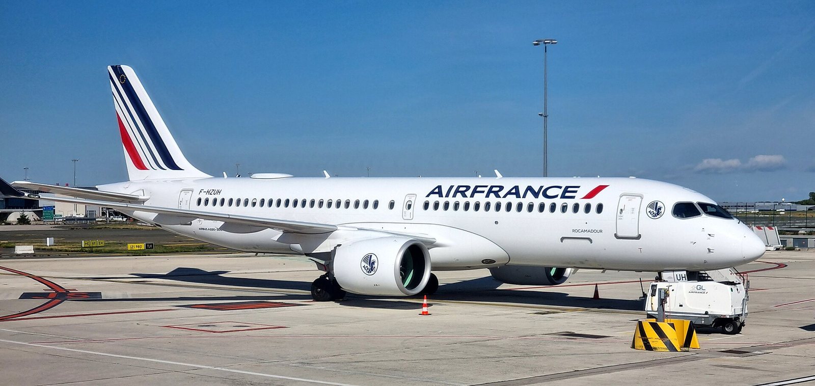 Un Airbus A220-300 d’Air France stationné sur le tarmac de Roissy-Charles-de-Gaulle, sous un ciel bleu