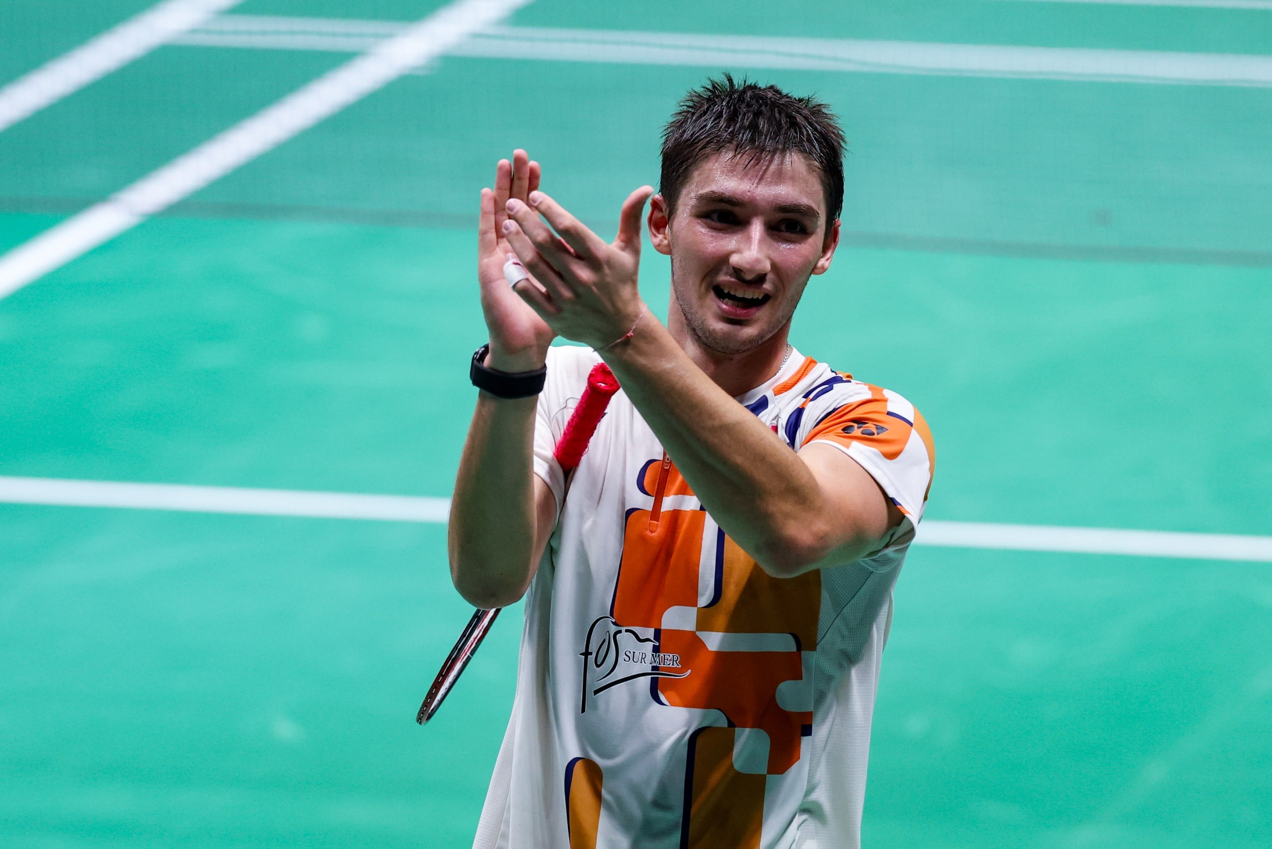 Christo Popov applaudit, sourire aux lèvres, raquette à la main, sur le court des Internationaux de France