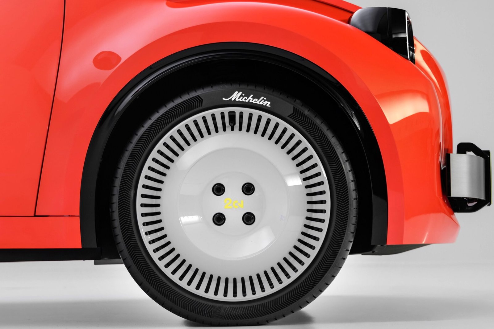 Gros plan sur une roue de la 2 CV Concept, jante façon tôle et pneu Michelin à logo rétro