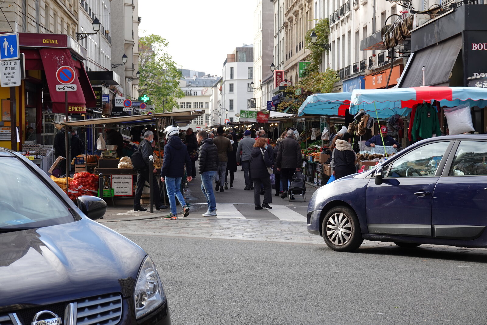 Passants et étals de fruits sur le marché de la rue d’Aligre à Paris