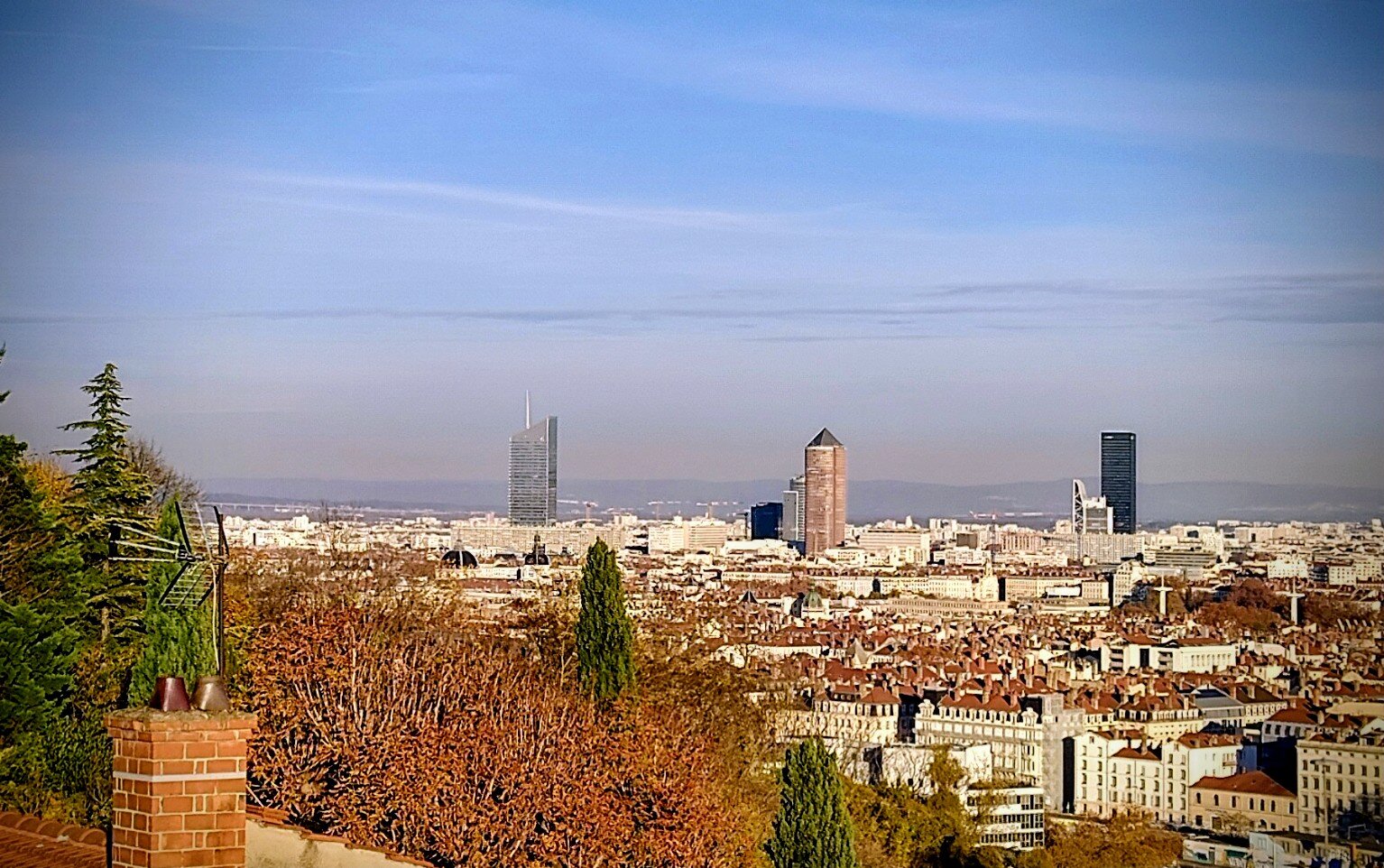 Vue sur les toits de Lyon et les tours du quartier de la Part-Dieu sous un ciel dégagé