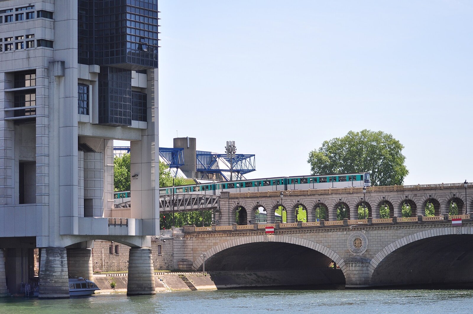 Le bâtiment du ministère de l’Économie et des Finances enjambe la Seine à côté du pont de Bercy, où passe une rame de métro