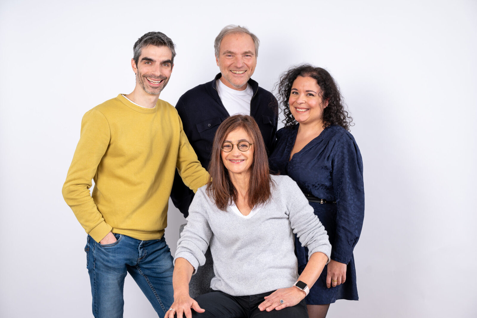 Les quatre cofondateurs de Dougs posent en studio, trois debout et une femme assise au premier plan