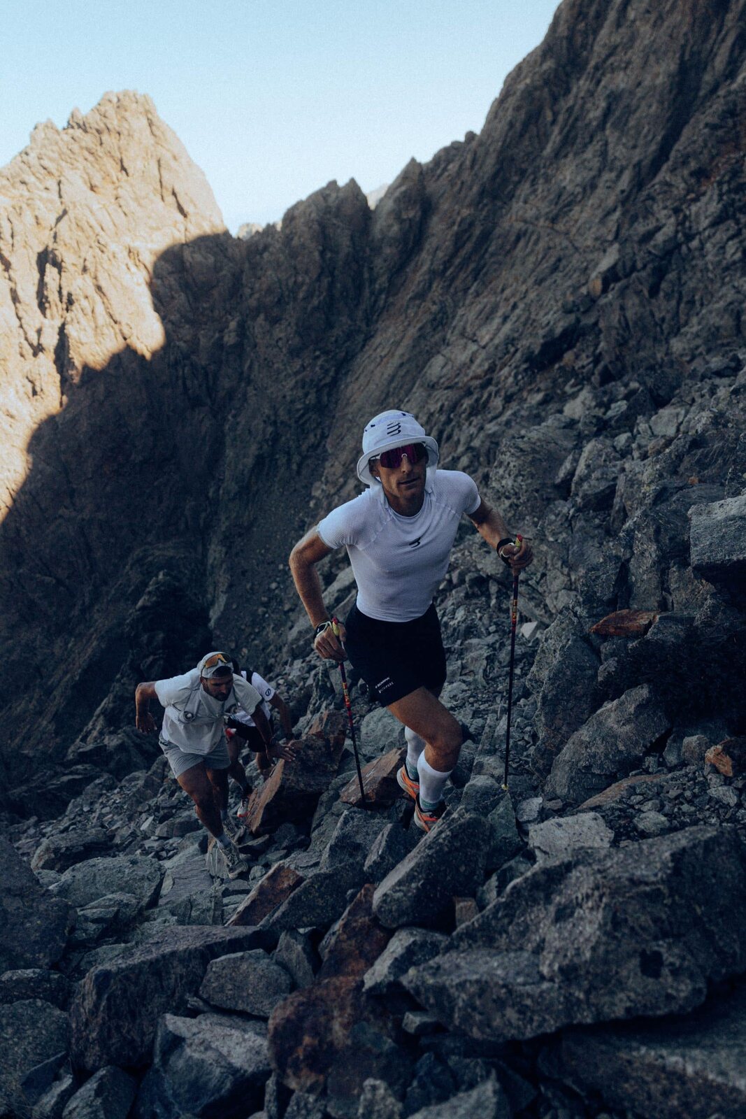 Aurélien Dunand-Pallaz escalade un passage rocheux, suivi d’un pacer