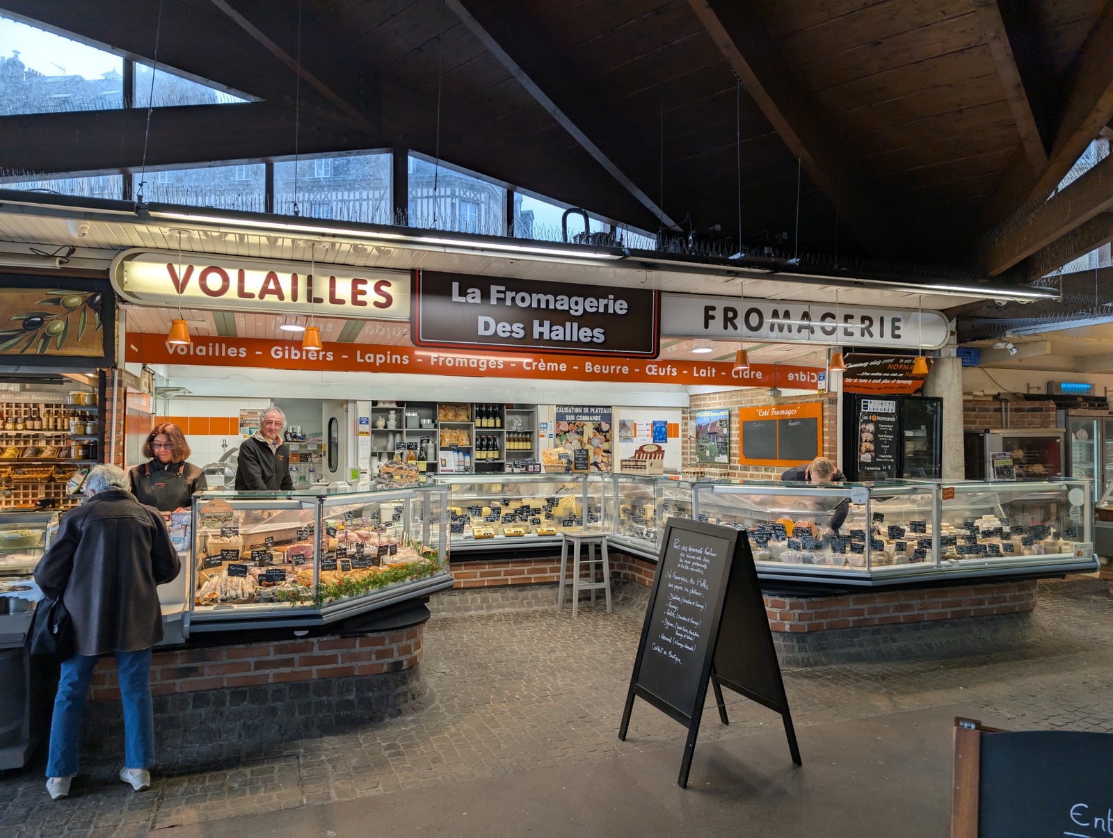Étal de fromages à la coupe dans une fromagerie