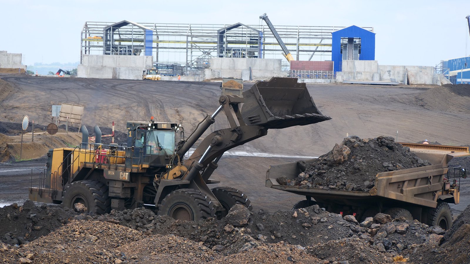 Une chargeuse remplit un camion de minerai de manganèse dans la mine de Moanda