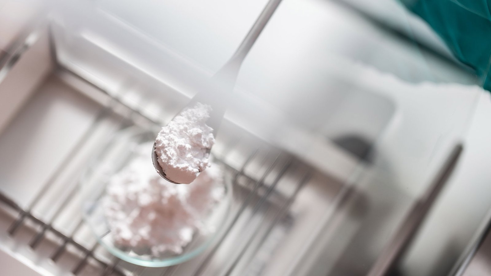 Gros plan sur des cristaux blancs de carbonate de lithium dans un récipient de laboratoire