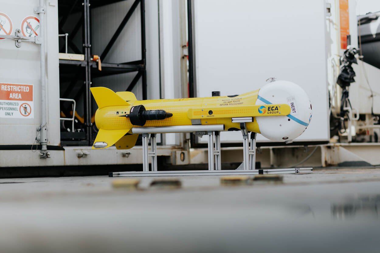 Robot sous-marin K-Ster jaune posé sur son support dans un hangar de navire