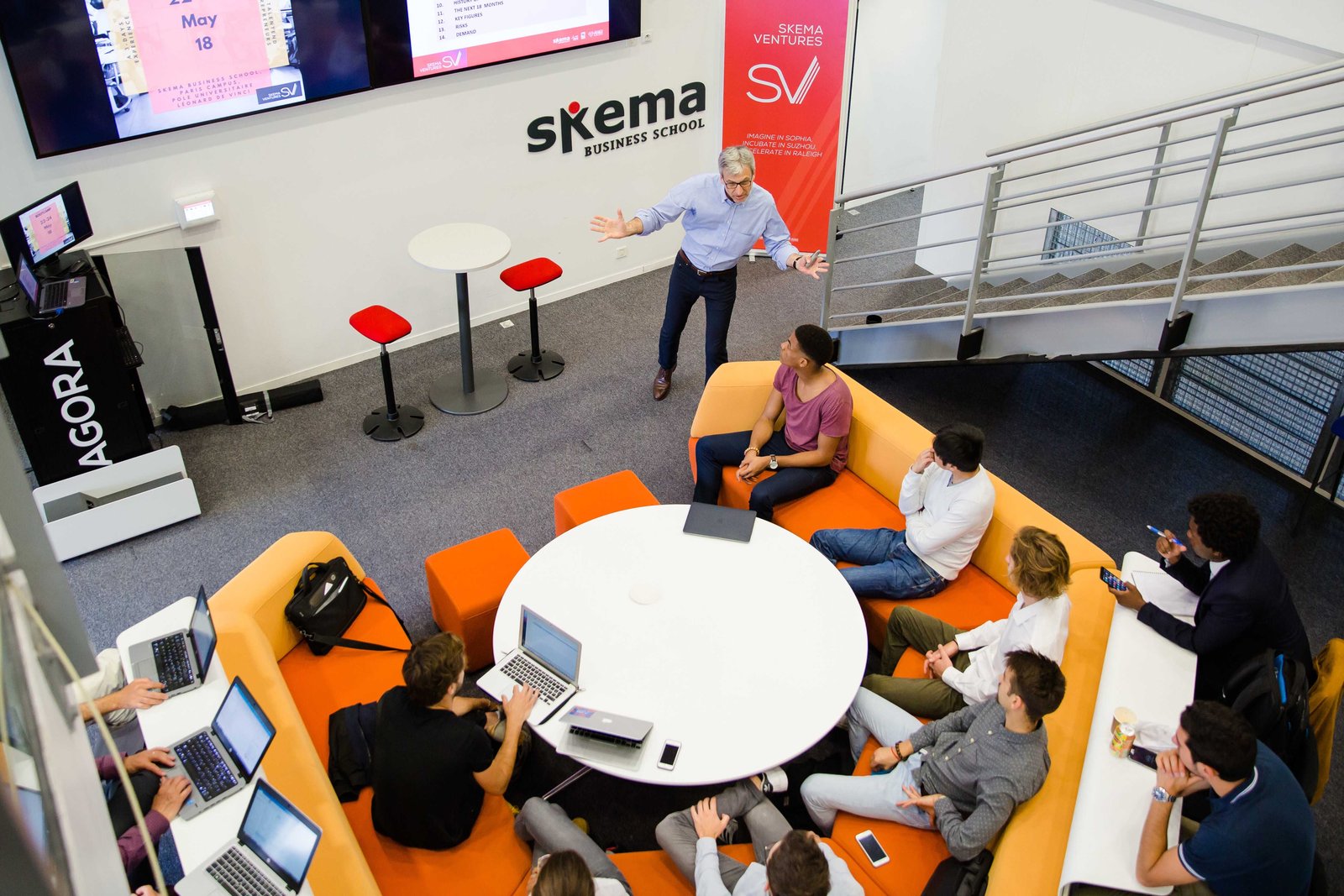 Des participants travaillent sur leurs ordinateurs autour d’une table ronde dans un espace de SKEMA Ventures