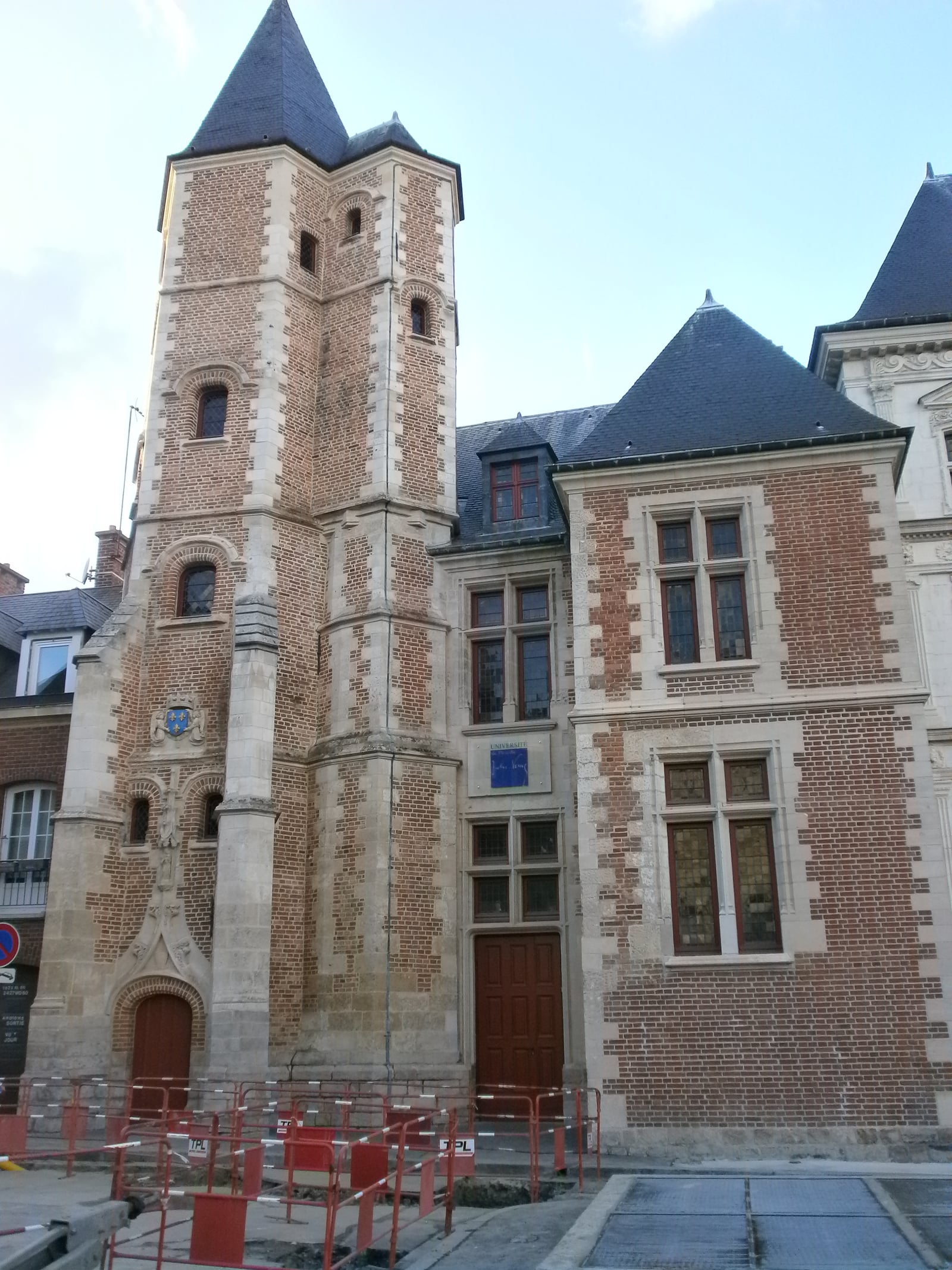 Façade en brique et pierre du Logis du Roi à Amiens, sous un ciel clair