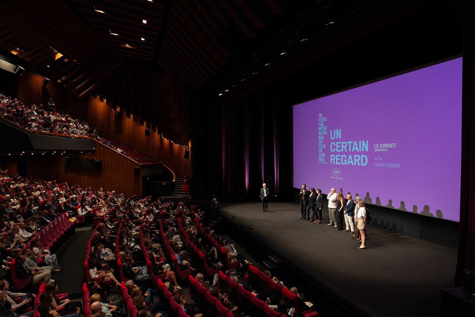 Louis Clichy et son équipe sur la scène d’une grande salle de cinéma devant un écran Un certain regard
