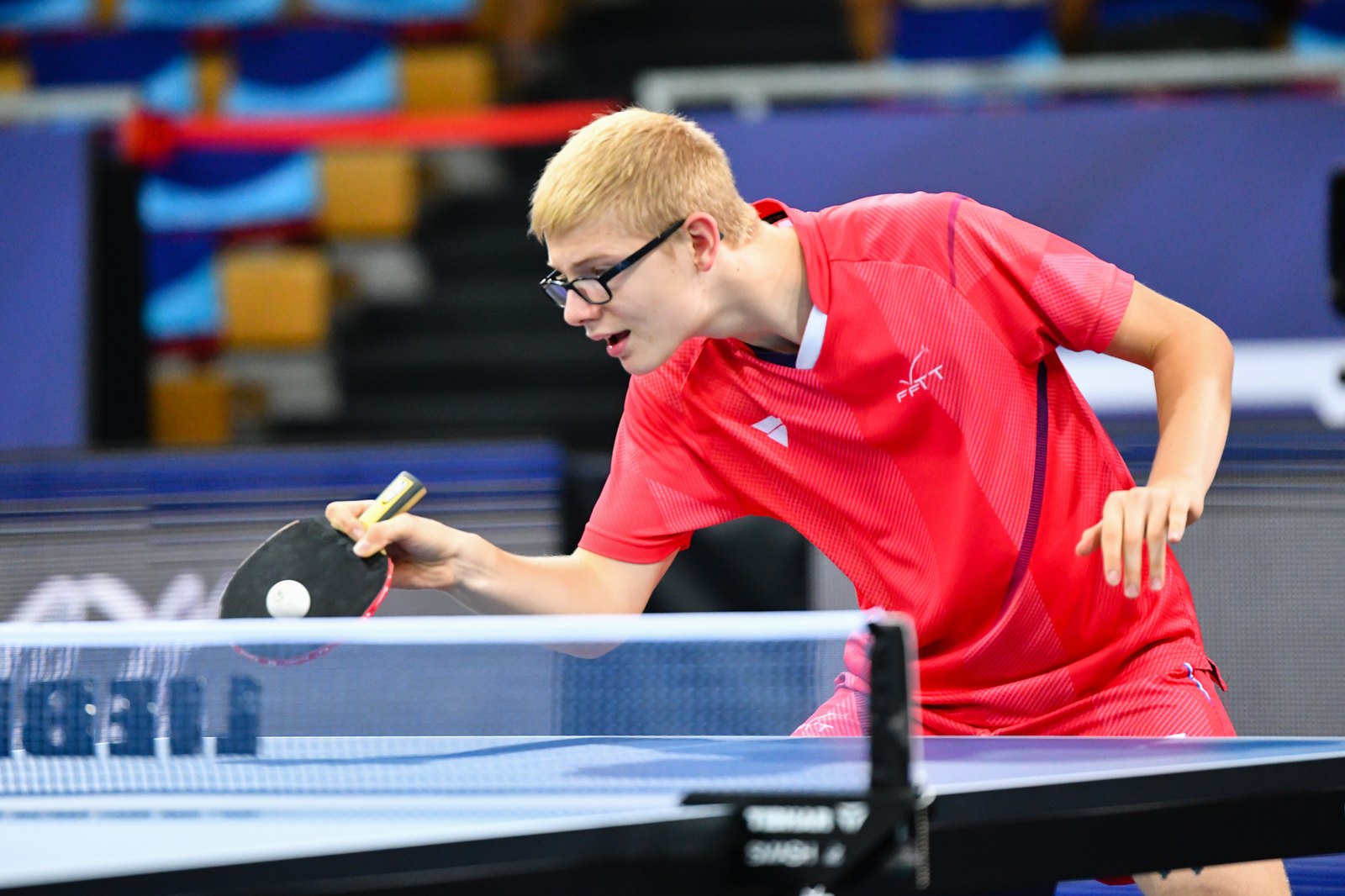 Félix Lebrun penché sur la table, revers prêt, regard concentré