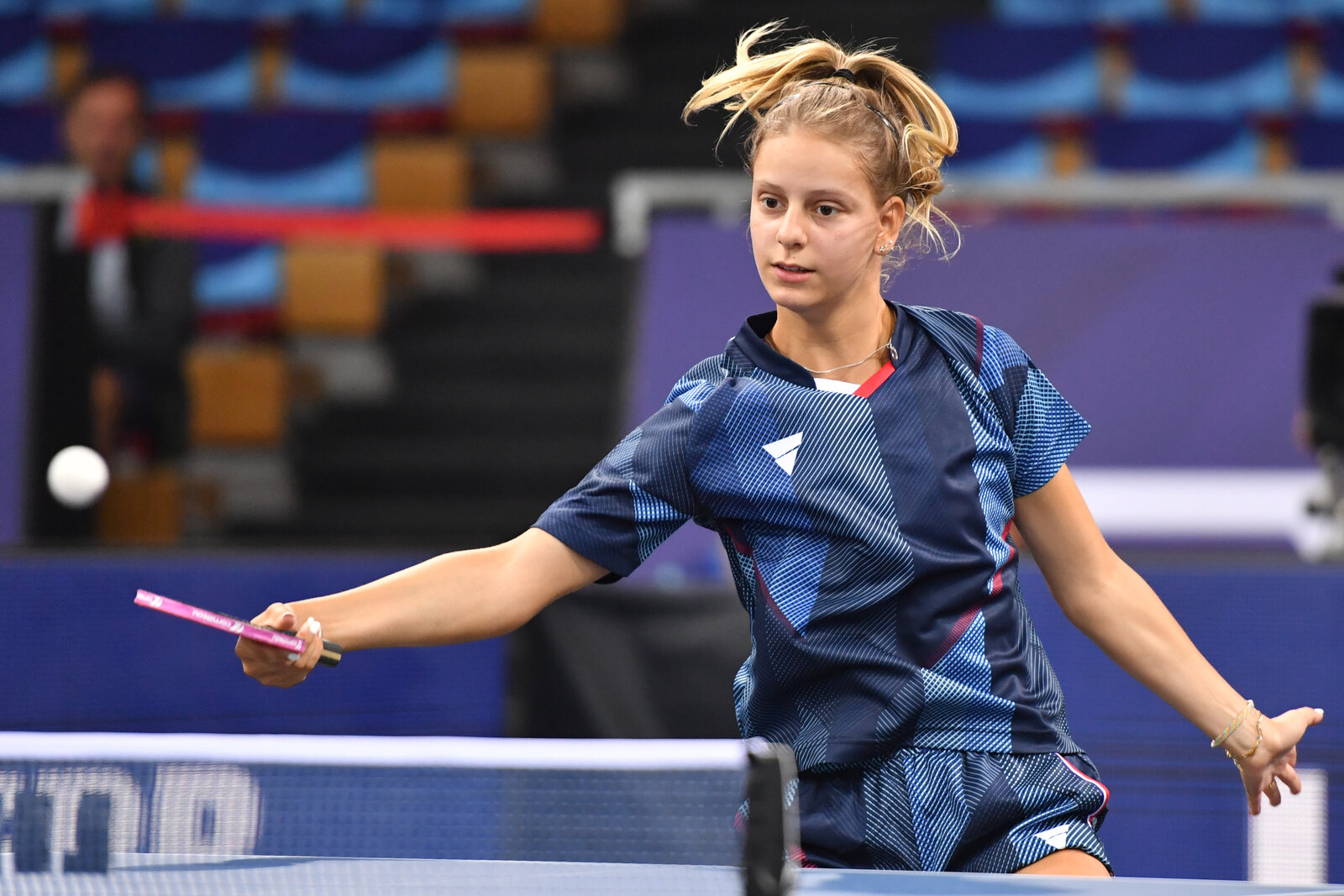 Charlotte Lutz au service, regard concentré, bras en arrière