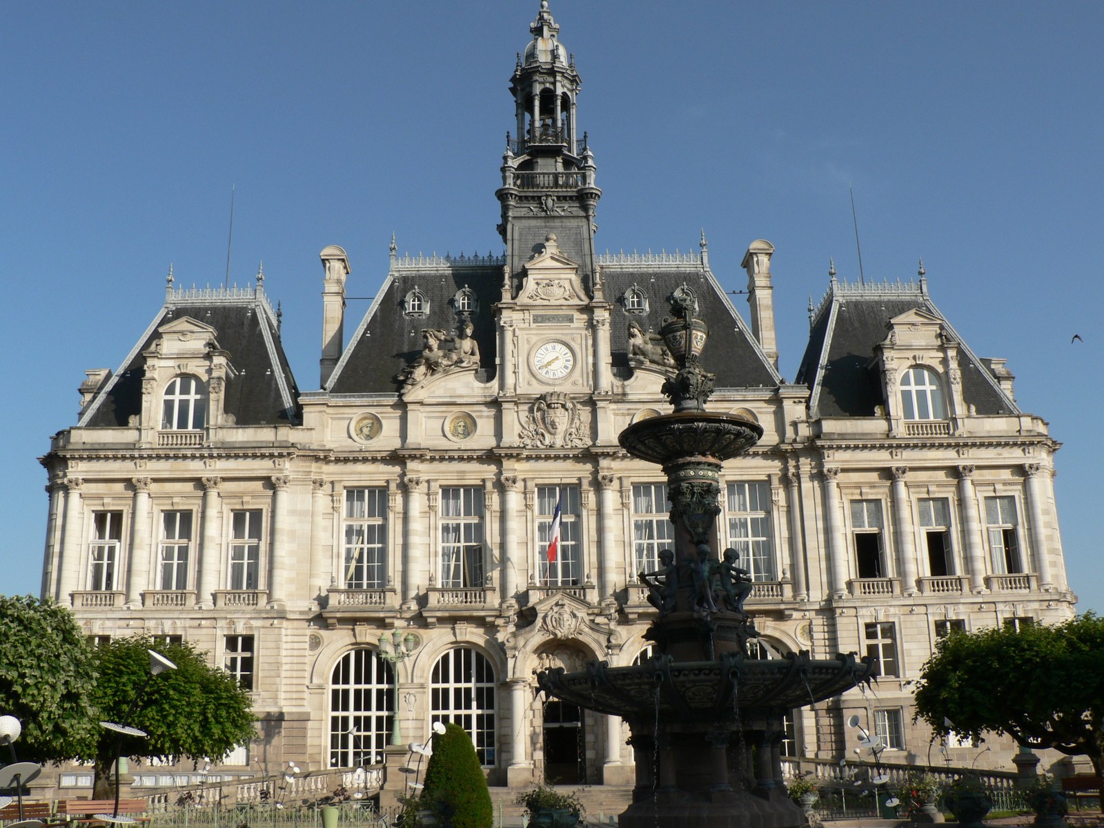 L’hôtel de ville de Limoges avant l’incendie, façade claire, toits d’ardoise et campanile, derrière la fontaine de la place