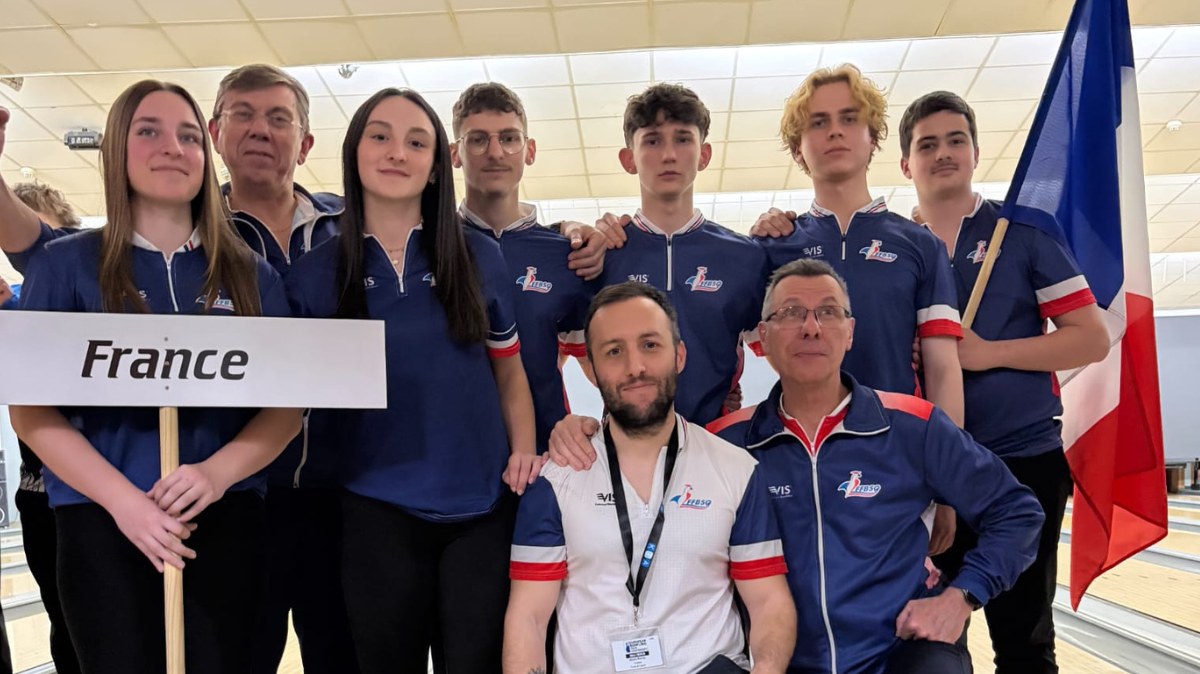 Les jeunes de l’équipe de France de bowling posent avec leurs entraîneurs, un panneau France et un drapeau tricolore, aux Championnats d’Europe jeunes de Berlin