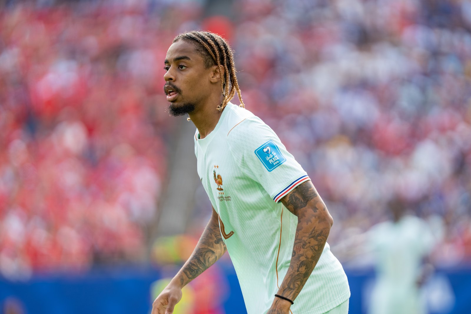 Bradley Barcola, tresses et maillot bleu de l’équipe de France, le regard concentré