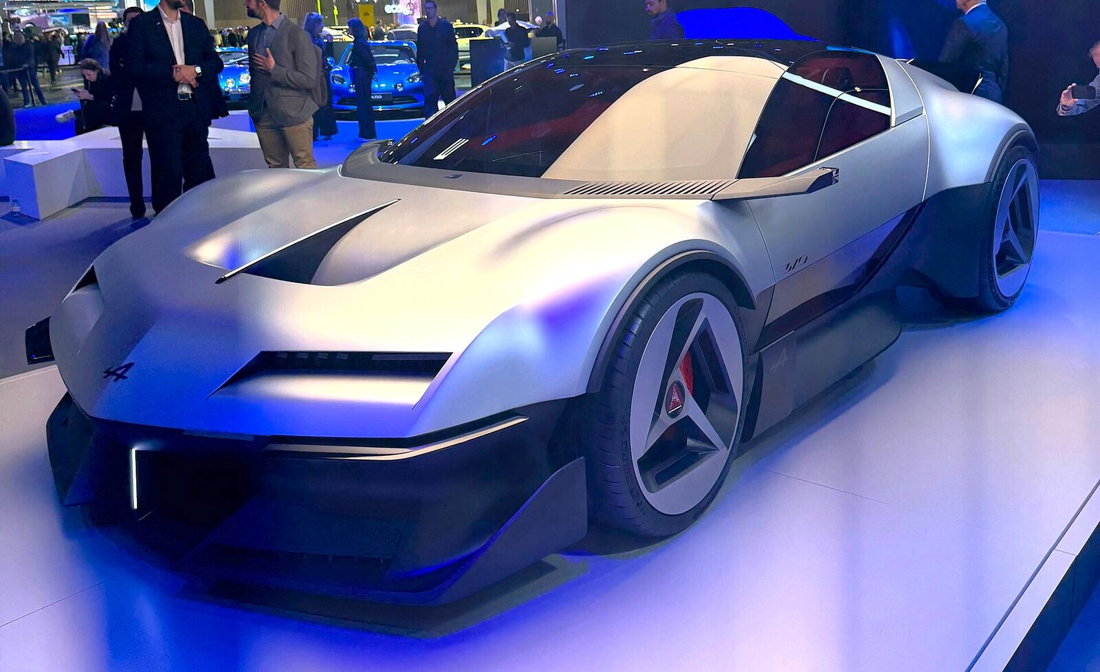 L’Alpine A310 Vision gris argent, capot plongeant et bulle vitrée, sous les éclairages bleus du stand Alpine
