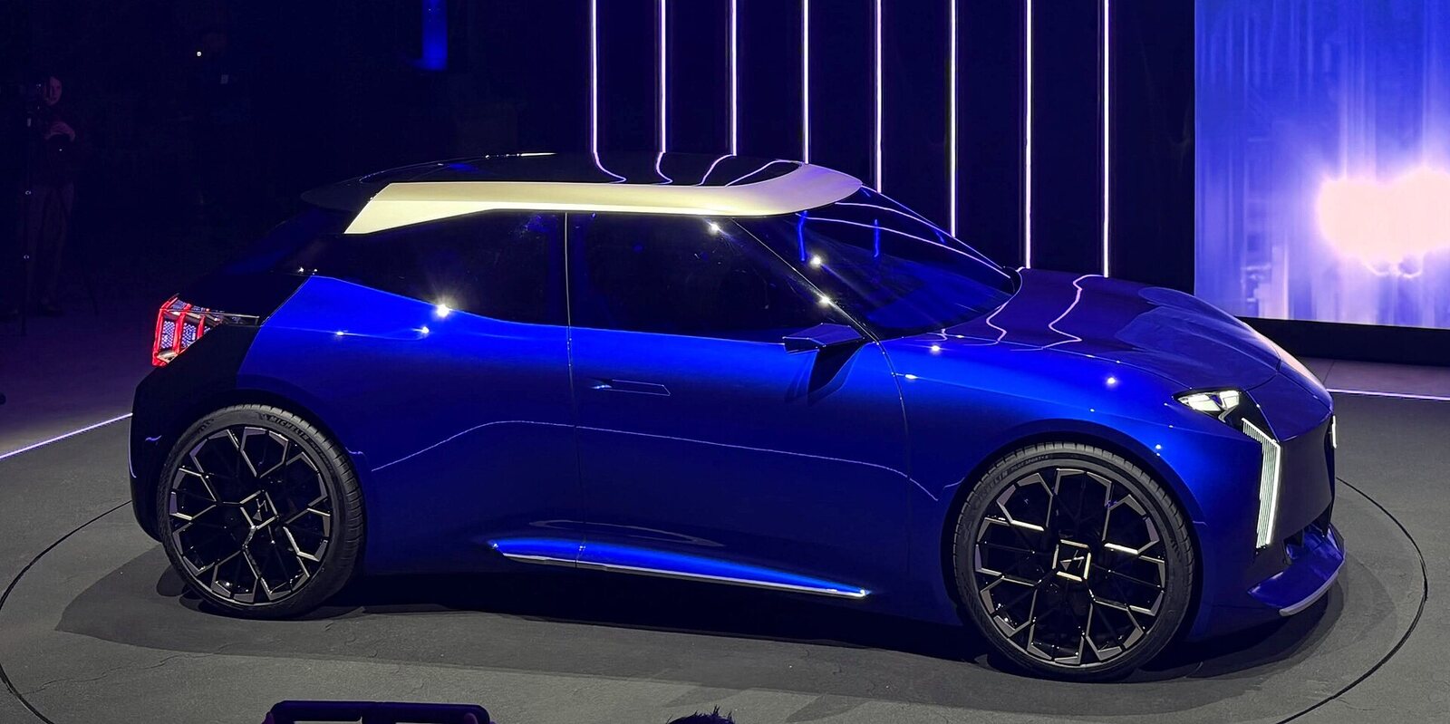 Le concept DS F3VER bleu dichroïque à toit clair, vu de profil sur un plateau éclairé