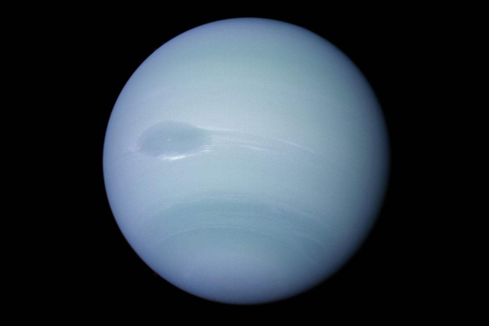 Neptune, planète bleu pâle, avec sa Grande Tache sombre, photographiée par Voyager 2