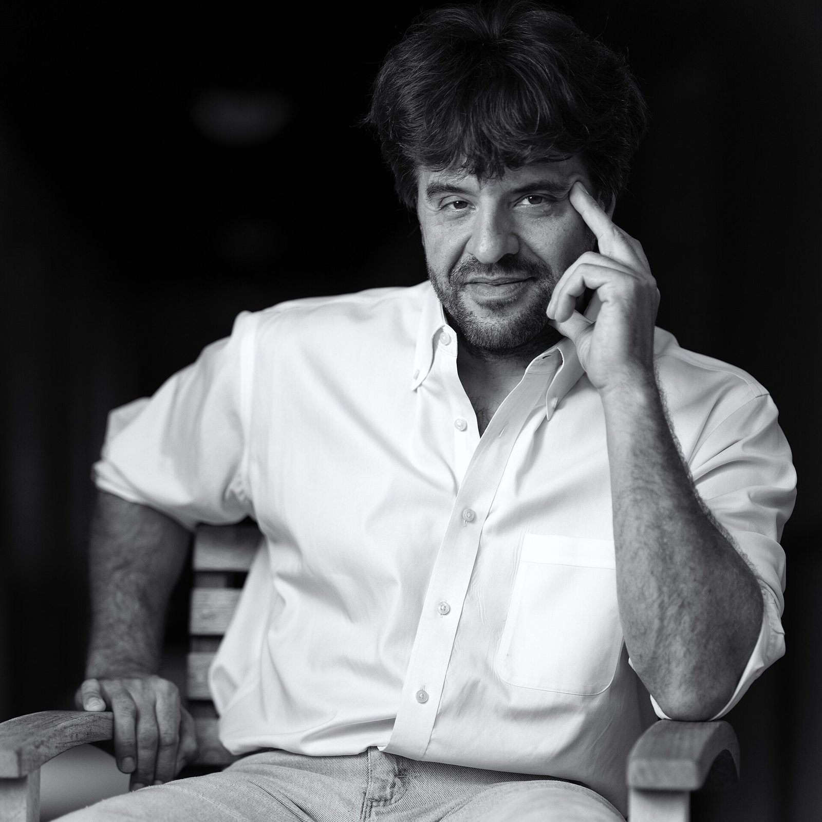 Portrait en noir et blanc de Karl Deisseroth, assis, la main droite près du visage