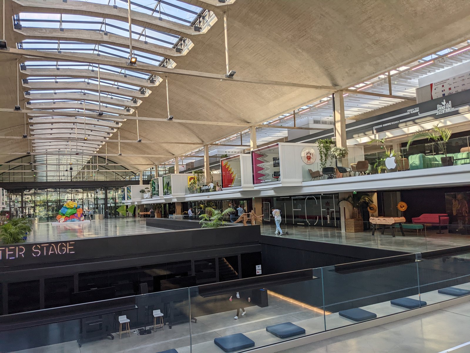 La grande halle de Station F à Paris, avec ses verrières et ses espaces de travail sur deux niveaux