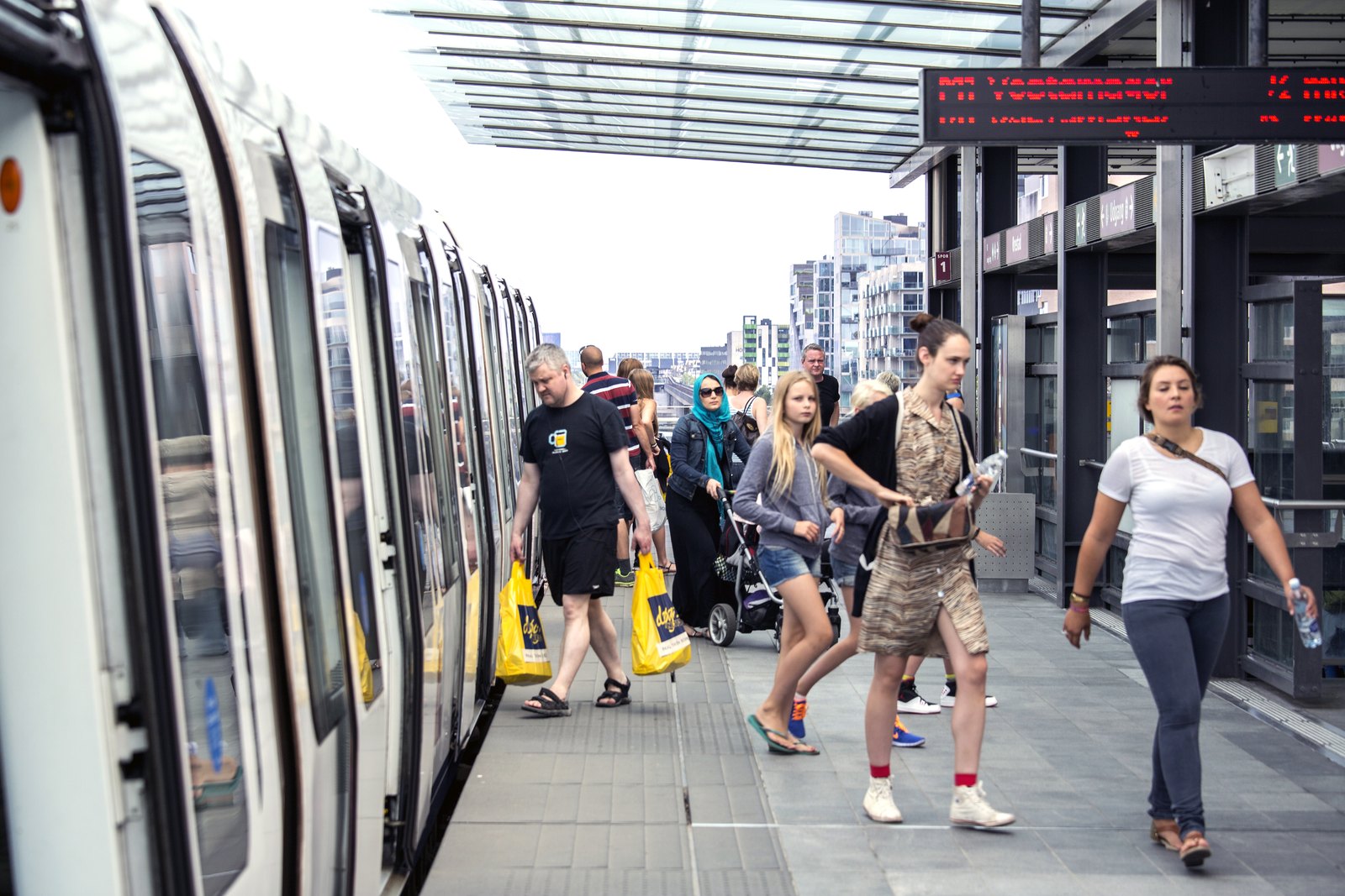 Voyageurs sortant d’une rame sur le quai aérien de la station Ørestad