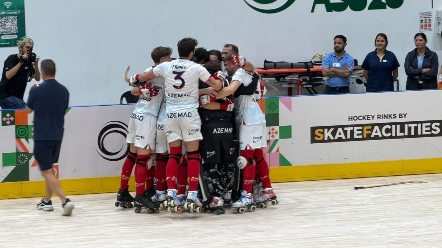 Les joueurs français, maillots blancs, se serrent dans une mêlée de joie devant le but après leur qualification pour la finale