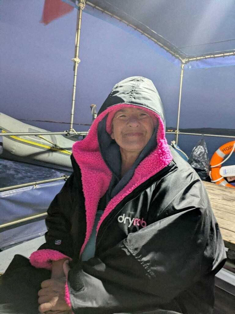 Salima Bouayad Agha, emmitouflée dans une parka noire à capuche, sourit à bord du bateau