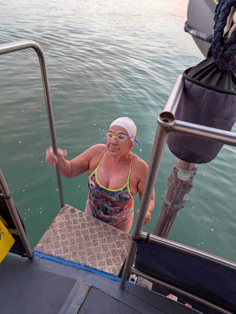 Salima Bouayad Agha, bonnet rose, remonte à l’échelle du bateau accompagnateur