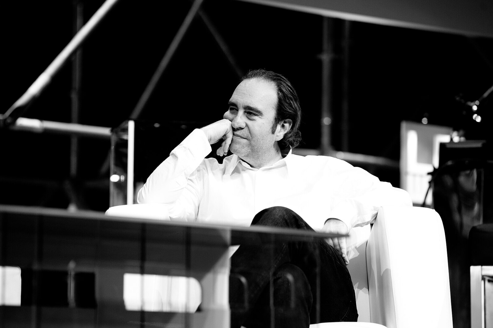 Xavier Niel assis, la main sous le menton, en noir et blanc