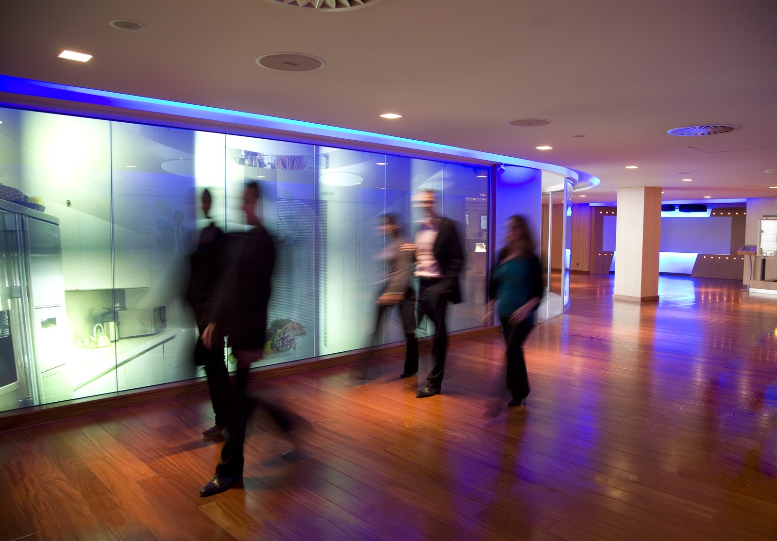Couloir technologique du New Electric World Center à Rueil-Malmaison, avec des collaborateurs en mouvement