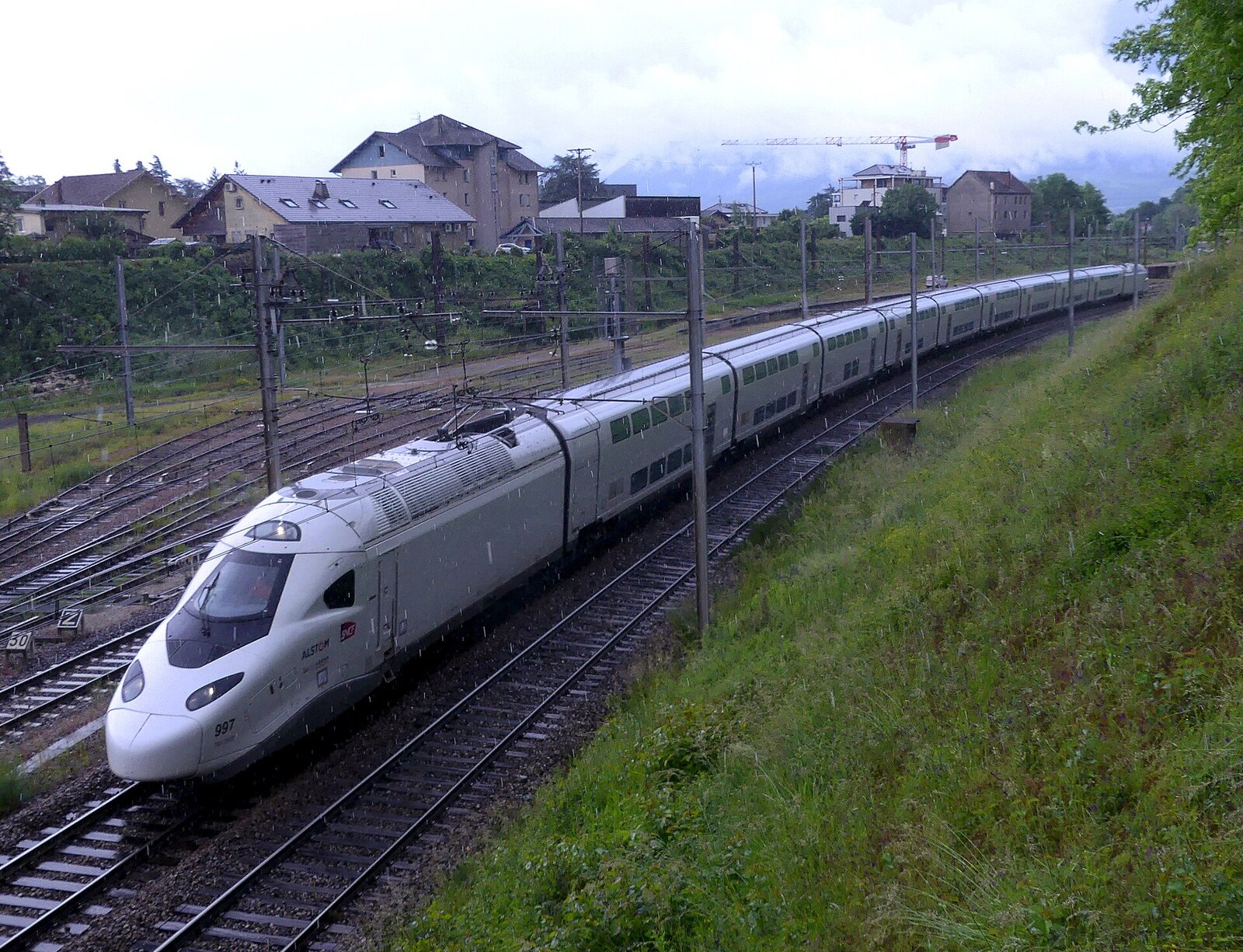 TGV M blanc dans une courbe, longeant un talus herbeux à Montmélian