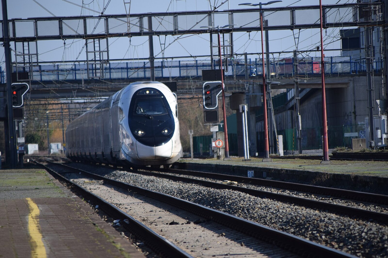 Nez d’un TGV M entrant en gare de Tournai, sous des portiques métalliques