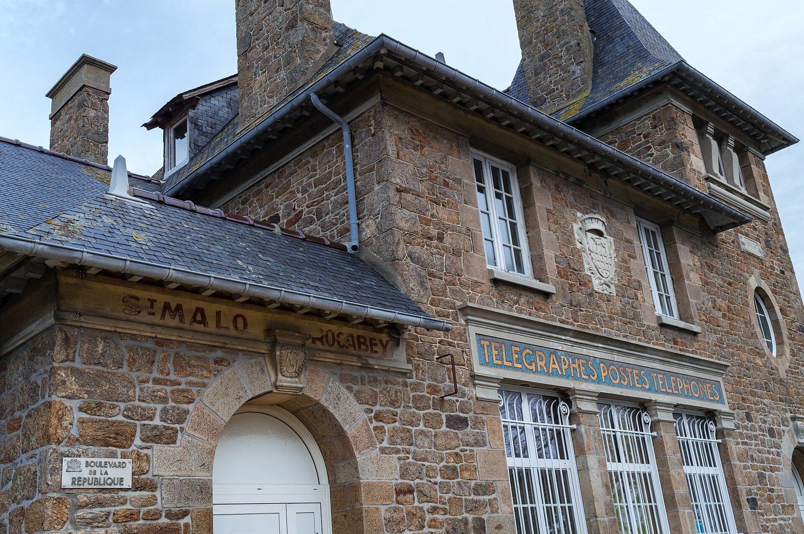 Façade d’un bureau de La Poste sur le boulevard de la République à Saint-Malo, enseigne jaune et boîtes aux lettres