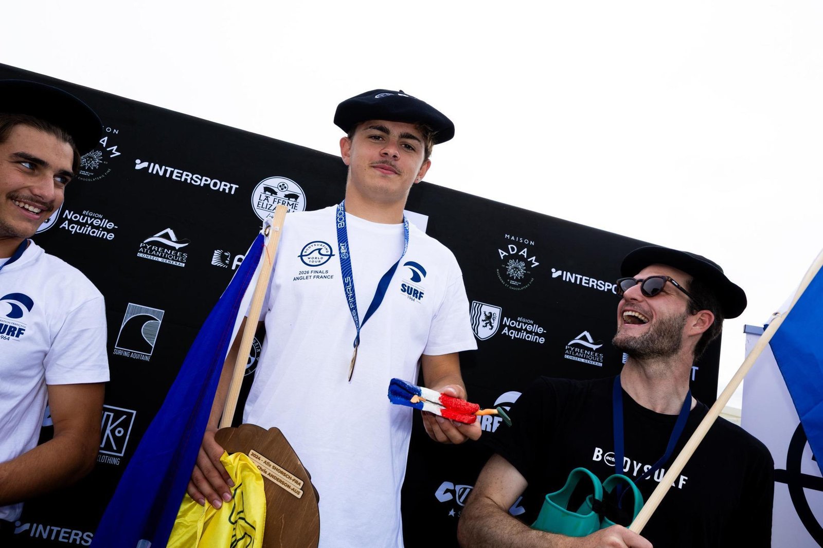 Trois finalistes, bérets basques sur la tête, posent avec leurs trophées sur le podium masculin d’Anglet