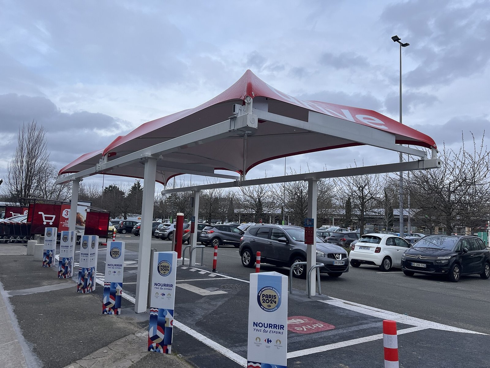 Bornes de retrait d’un drive Carrefour Market sous un auvent