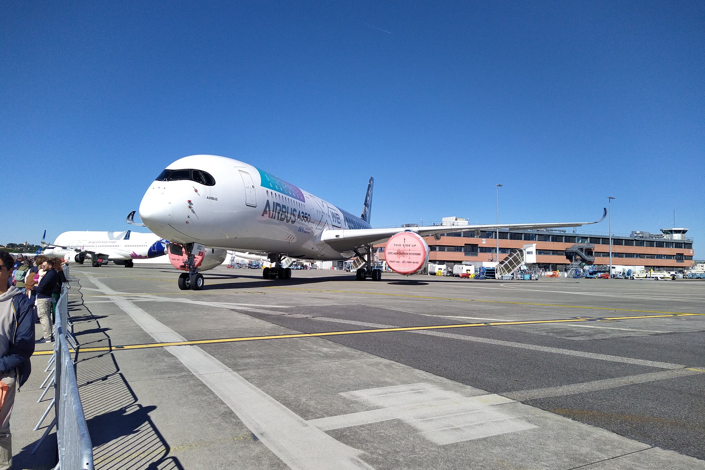 Un Airbus A350-900 aux couleurs d’Airbus exposé sur le tarmac de Saint-Martin-du-Touch, à Toulouse, devant des visiteurs