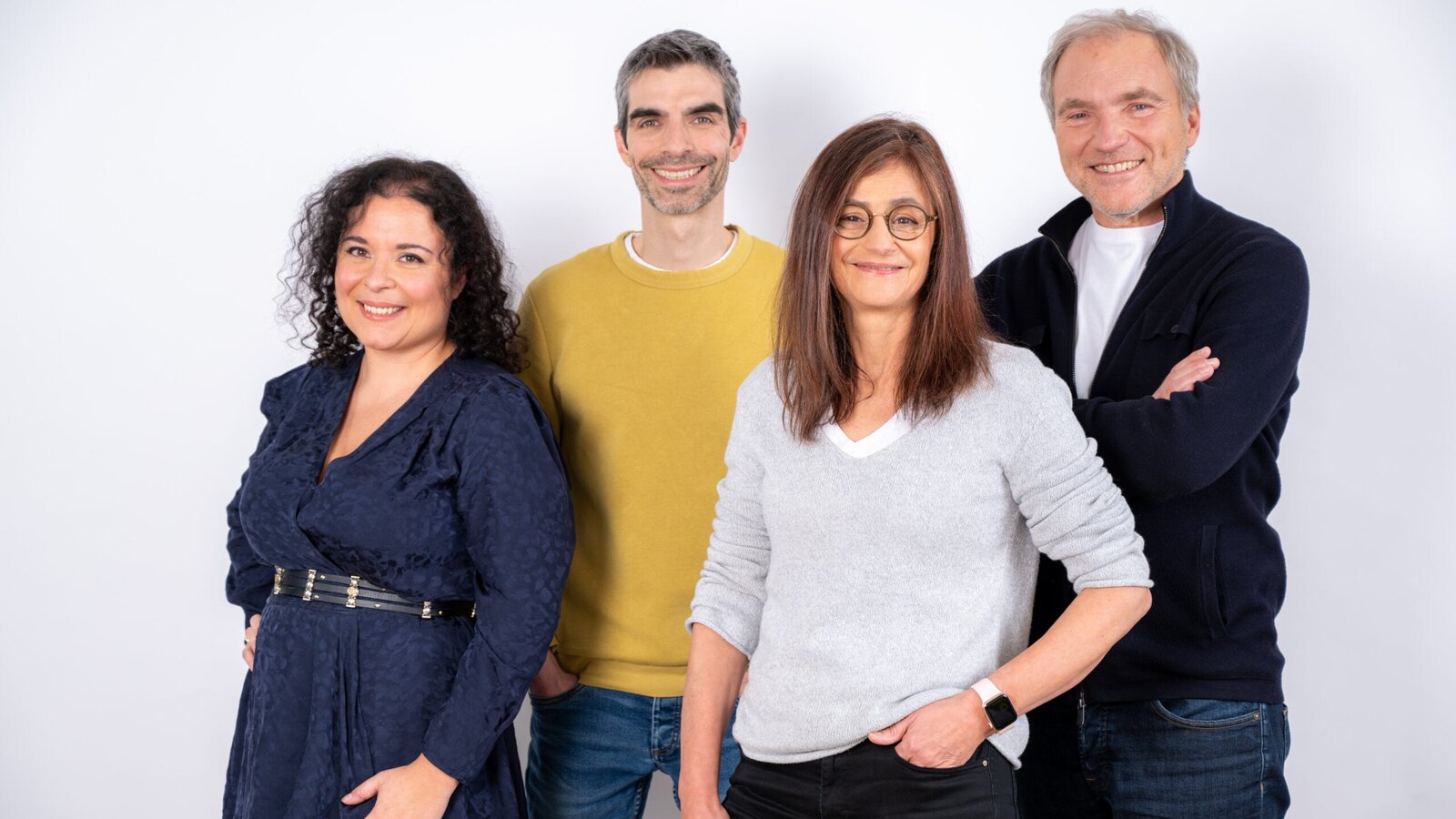 Les quatre cofondateurs de Dougs, deux femmes et deux hommes, sourient côte à côte sur un fond blanc de studio