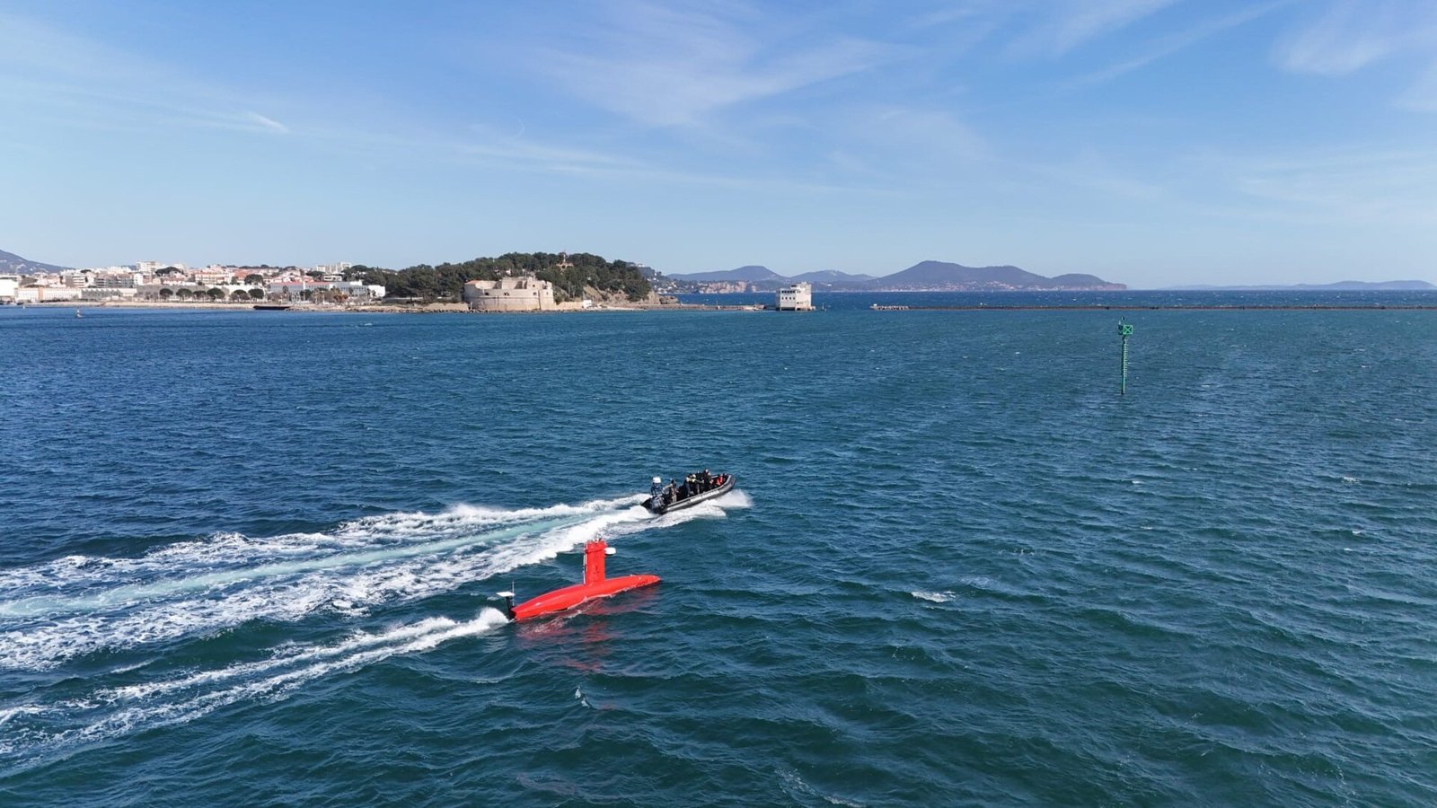 Un drone de surface DriX de la Marine nationale lancé à pleine vitesse, sillage blanc sur la mer bleue