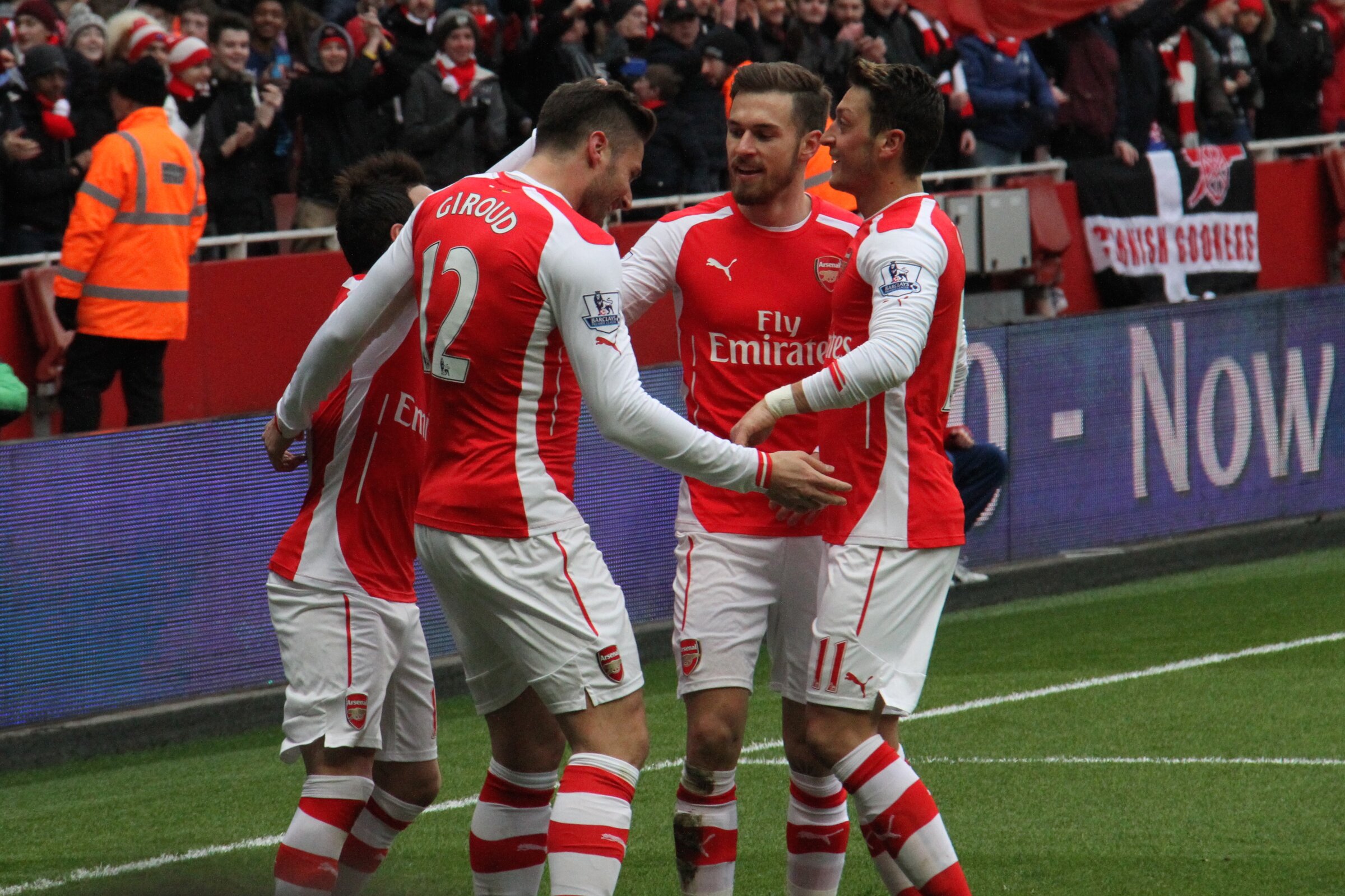 Olivier Giroud, maillot d’Arsenal floqué du numéro 12, félicité par ses coéquipiers devant les supporters de l’Emirates Stadium (photo d’archive, février 2015)