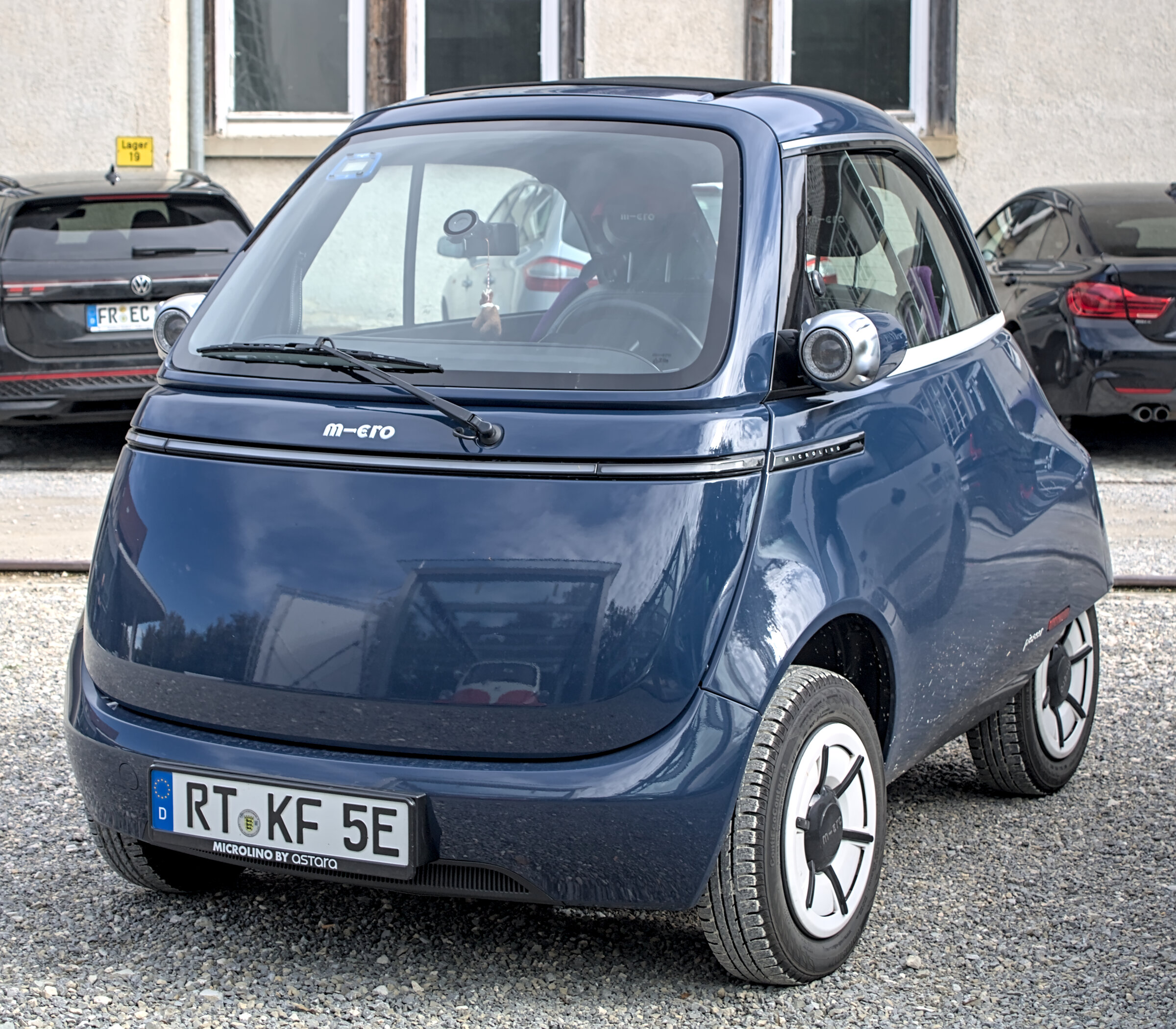Une Microlino électrique jaune et noire exposée sur un salon automobile, photo d’illustration