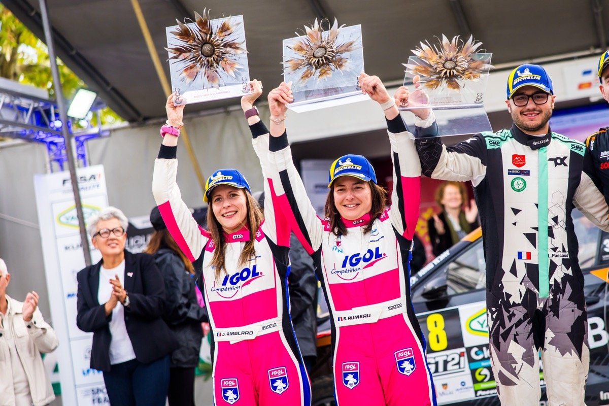 Sarah Rumeau et Julie Amblard, en combinaison rose et blanche, lèvent leurs trophées au-dessus de la tête et sourient sur le podium du Terre des Cardabelles