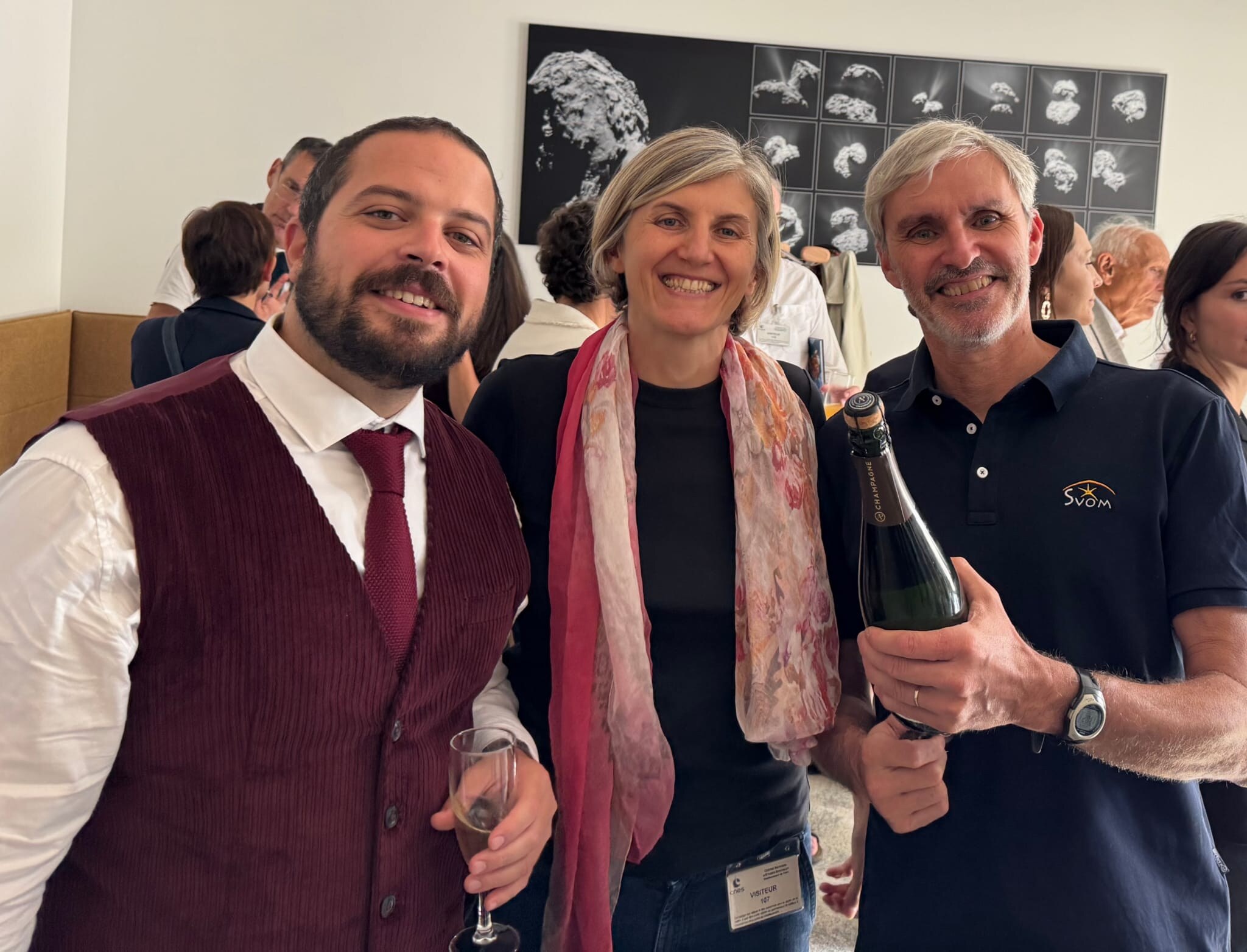 Susanna Vergani, Bertrand Cordier, bouteille de champagne en main et polo SVOM, et Andrea Saccardi, tout sourire, célèbrent le prix au siège du CNES